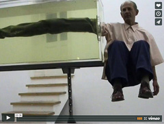 Man suspended one meter above the ground, posing with aquarium